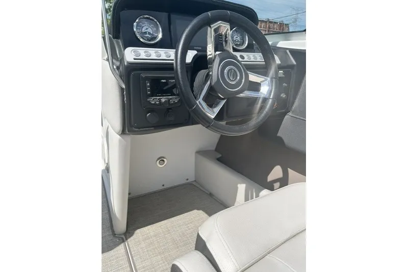 Slide: The Image of 2022 Crownline 240 SS boat interior with steering wheel and dashboard controls. - 11