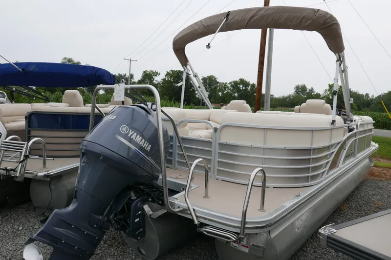 Slide: The Image of 2014 Bennington 2250GSR pontoon boat with Yamaha outboard motor, parked on gravel. - 2