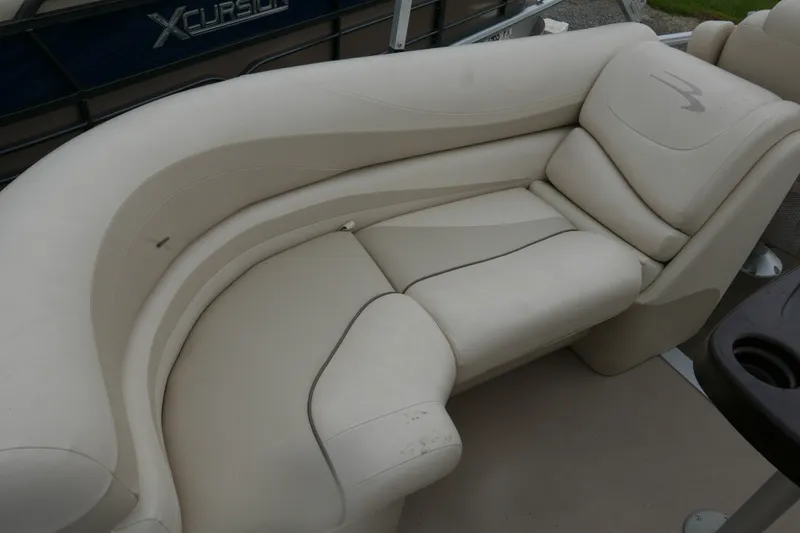 Slide: The Image of Cream-colored seating on a 2014 Bennington 2250GSR boat, featuring plush upholstery. - 12
