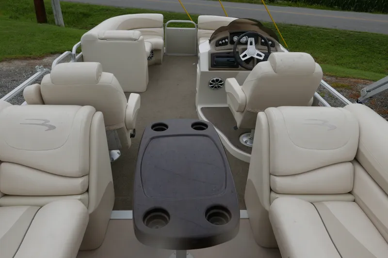 Slide: The Image of 2014 Bennington 2250GSR pontoon boat interior with beige seating and steering console. - 14