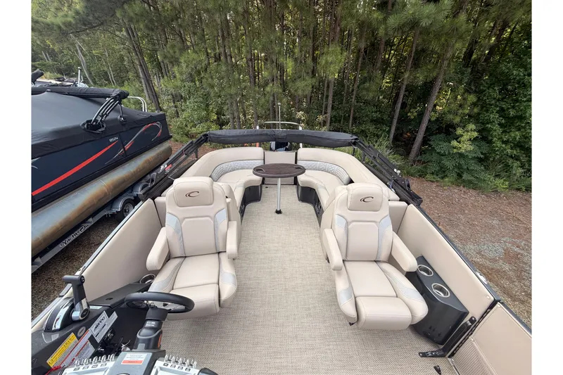Slide: The Image of 2023 Crest Carribbean 250 SLC pontoon boat interior with plush seating and table. - 6