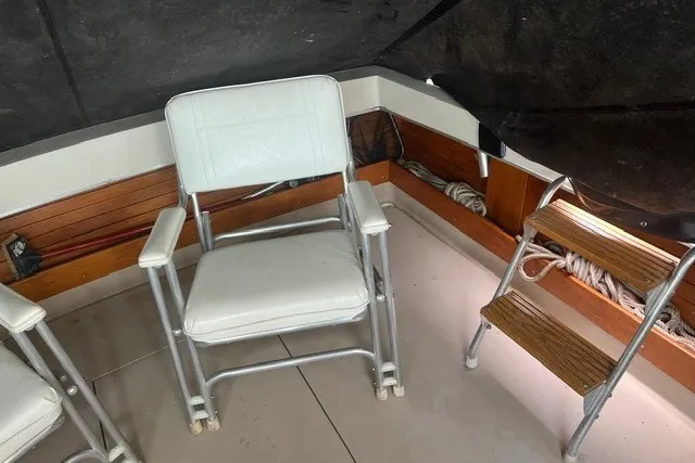 Slide: The Image of 1975 Slickcraft 28 EXPRESS boat interior with white chair and wooden steps. - 9