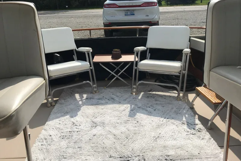 Slide: The Image of 1975 Slickcraft 28 EXPRESS boat interior with white chairs and a small table. - 11