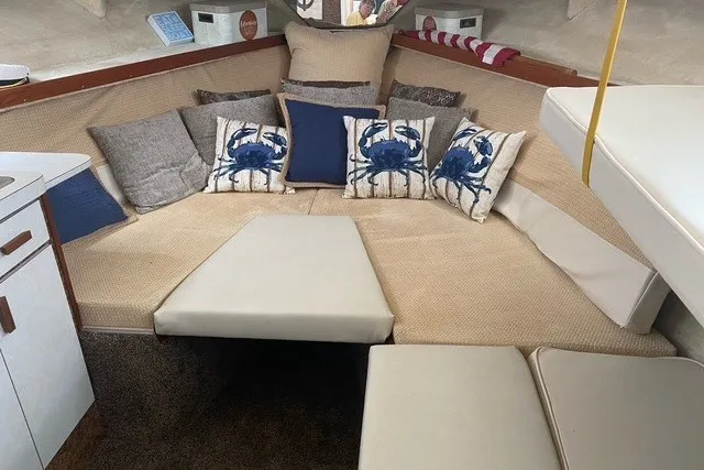 Slide: The Image of 1975 Slickcraft 28 EXPRESS boat interior with cozy seating and nautical-themed pillows. - 10