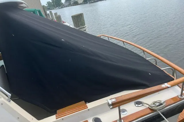Slide: The Image of 1975 Slickcraft 28 EXPRESS boat covered at dockside, featuring wooden railings and calm waters. - 3