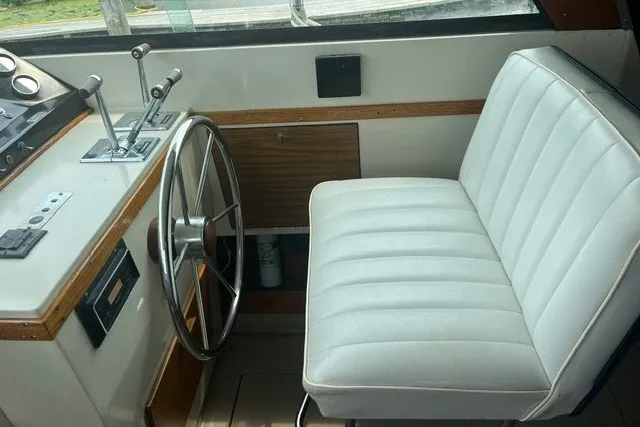 Slide: The Image of 1975 Slickcraft 28 EXPRESS boat interior with steering wheel and white captain's chair. - 7
