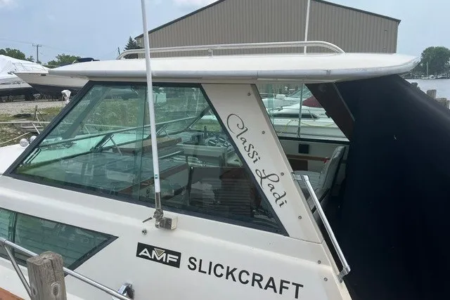 Slide: The Image of 1975 Slickcraft 28 EXPRESS boat docked, featuring "Classi Ladi" text on the side. - 2