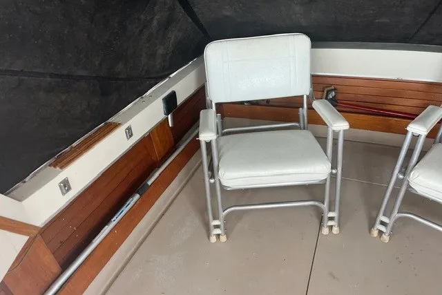 Slide: The Image of 1975 Slickcraft 28 EXPRESS boat interior with white chairs and wood paneling. - 8
