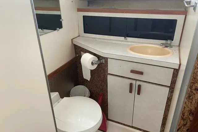 Slide: The Image of 1975 Slickcraft 28 EXPRESS boat bathroom with sink, toilet, and storage cabinets. - 14