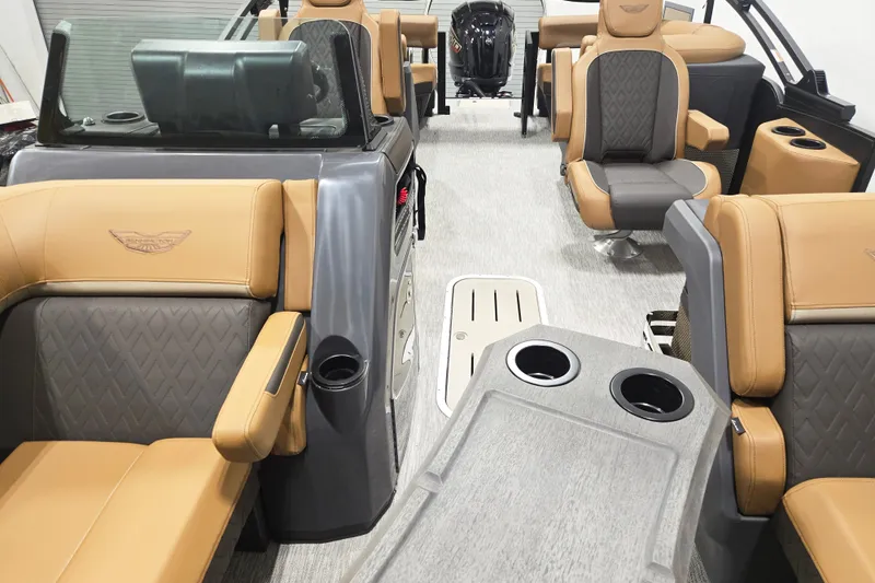 Slide: The Image of 2026 Bennington 22M Open FSB boat interior with tan and gray seating, cup holders, and modern design. - 6