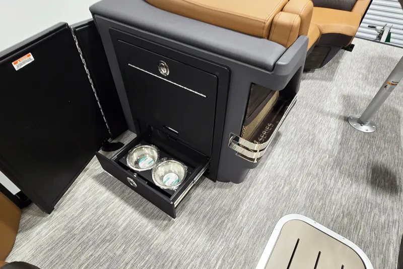 Slide: The Image of Interior of 2026 Bennington 22M Open FSB with storage drawer and pet bowls. - 7