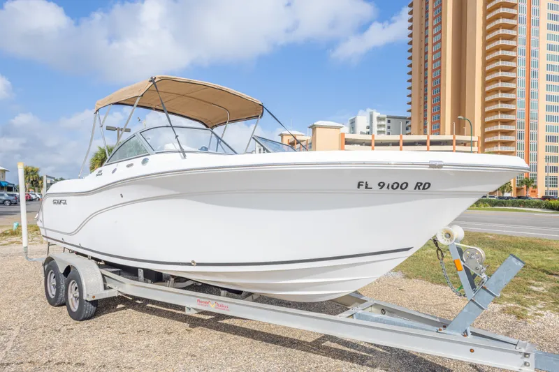 Slide: The Image of 2016 Sea Fox 226 Traveler boat on trailer, parked near tall buildings. - 11