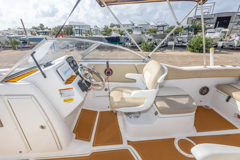 Slide: The Image of 2016 Sea Fox 226 Traveler boat interior with helm, steering wheel, and seating in a marina setting. - 30