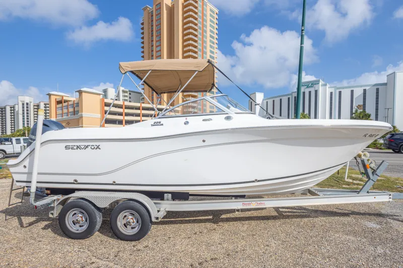 Slide: The Image of 2016 Sea Fox 226 Traveler boat on trailer, urban background, clear sky. - 12