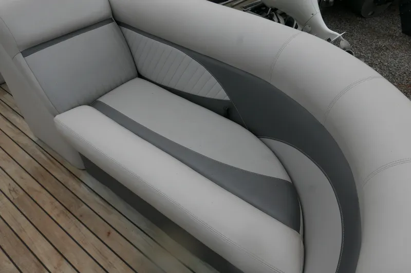 Slide: The Image of 2018 Crest II boat interior with gray and white cushioned seating on wooden deck. - 4