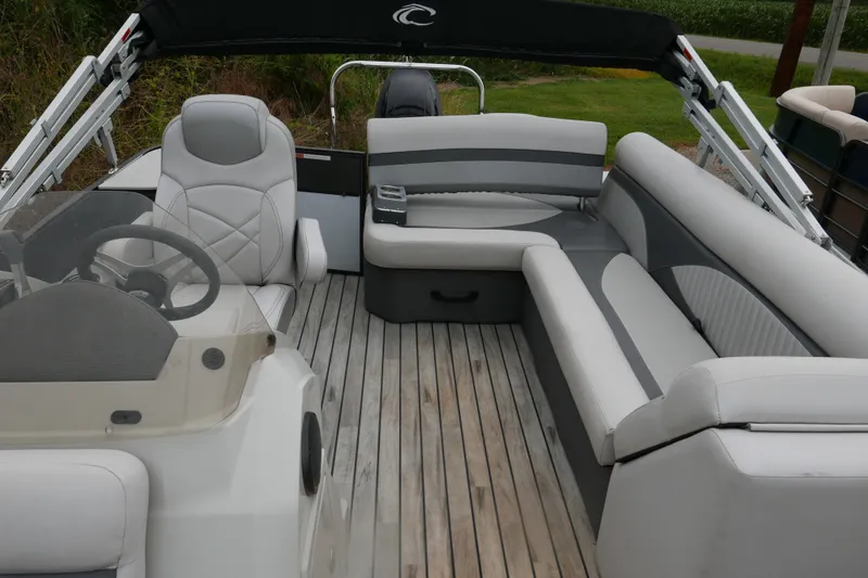 Slide: The Image of 2018 Crest II pontoon boat interior with gray seating and wooden deck. - 7