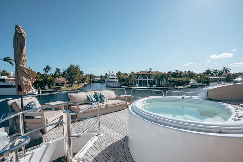 Slide: The Image of Luxurious 2004 Lazzara 106 yacht deck with jacuzzi and seating, overlooking serene waterfront. - 7