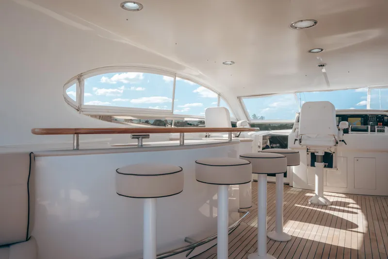 Slide: The Image of Luxurious 2004 Lazzara 106 yacht interior with bar stools and helm, featuring sleek design. - 19
