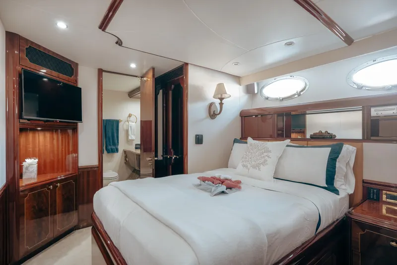 Slide: The Image of Luxurious bedroom interior on 2004 Lazzara 106 yacht, featuring elegant wood finishes and modern amenities. - 33
