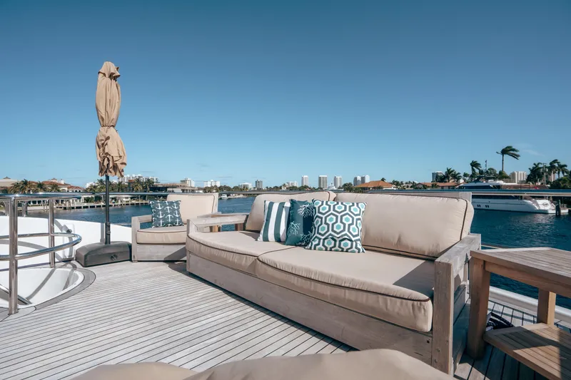 Slide: The Image of Luxurious deck seating on 2004 Lazzara 106 yacht, featuring plush cushions and scenic waterfront views. - 6
