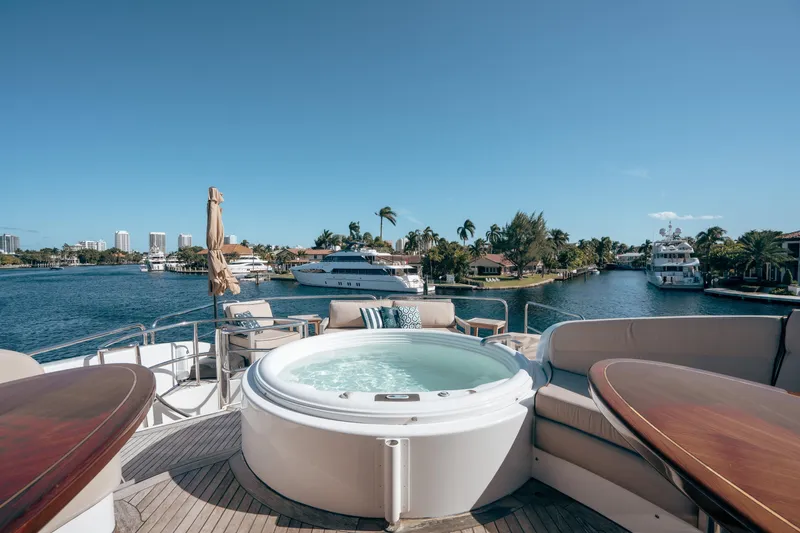 Slide: The Image of Luxurious 2004 Lazzara 106 yacht with jacuzzi on deck, overlooking scenic waterfront views. - 8