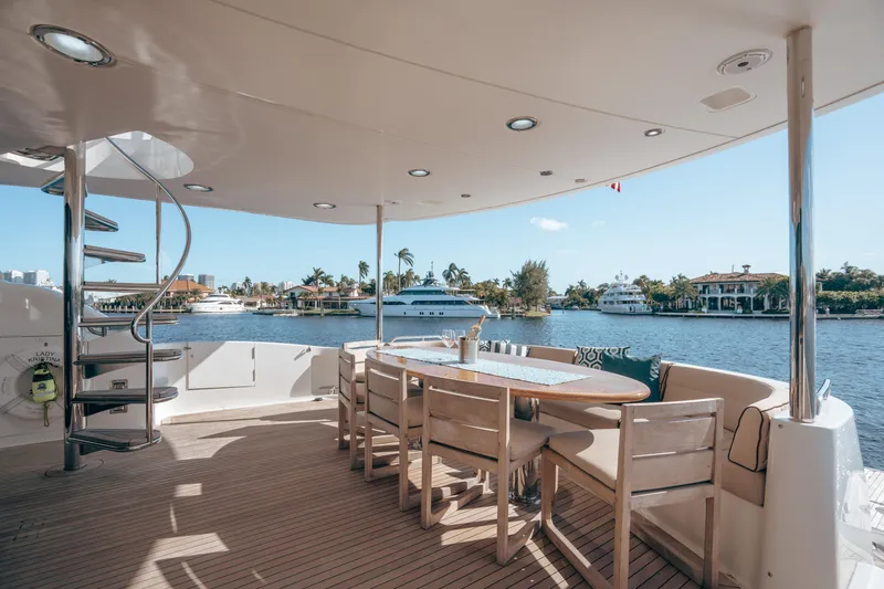 Slide: The Image of Luxurious 2004 Lazzara 106 yacht deck with dining area overlooking serene waterfront views. - 27