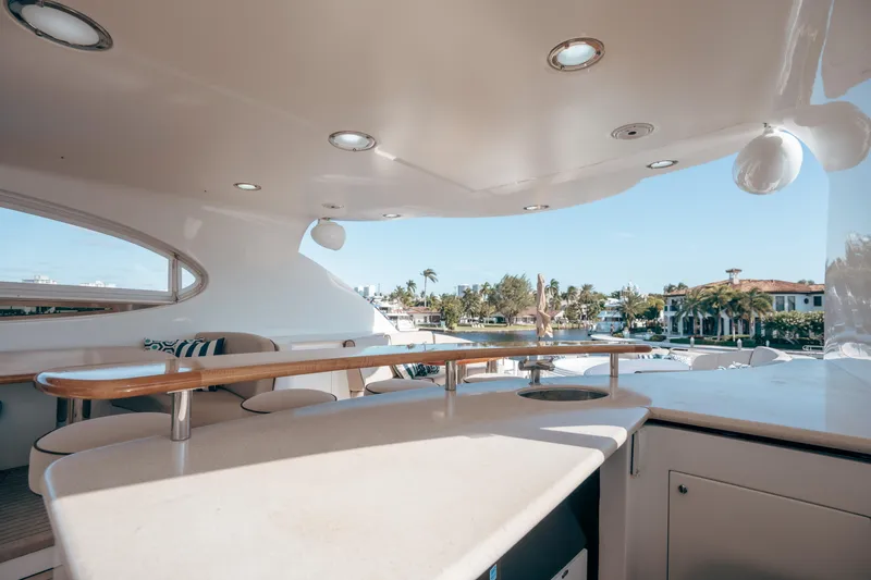 Slide: The Image of Luxurious 2004 Lazzara 106 yacht deck with elegant seating and scenic waterfront view. - 18