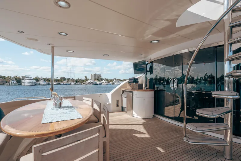 Slide: The Image of Luxurious 2004 Lazzara 106 yacht deck with elegant dining area and spiral staircase. - 24