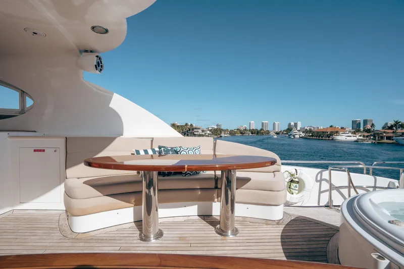 Slide: The Image of Luxurious 2004 Lazzara 106 yacht deck with seating, table, and waterfront view. - 11