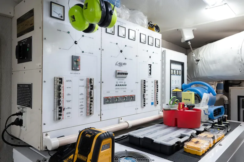 Slide: The Image of Electrical control panel in 2004 Lazzara 106 yacht engine room with tools and safety gear. - 72