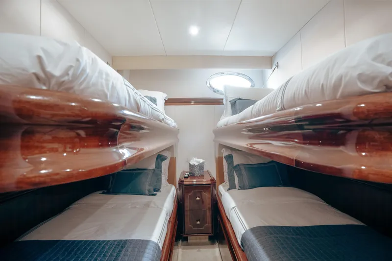 Slide: The Image of Luxurious cabin with bunk beds on a 2004 Lazzara 106 yacht, featuring elegant wood finishes. - 37