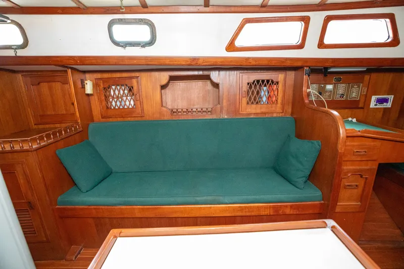 Slide: The Image of Interior of 1979 C&L Marine 36 sailboat with wooden cabinetry and green cushioned seating. - 27