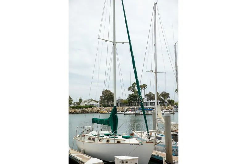 Slide: The Image of 1979 C&L Marine 36 sailboat docked in a marina with green sail cover. - 6