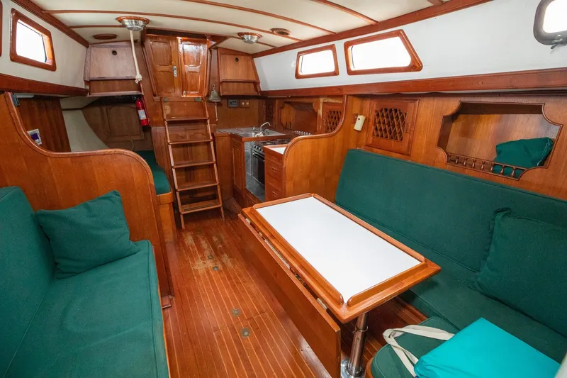 Slide: The Image of Interior of 1979 C&L Marine 36 sailboat with wooden finish and green seating. - 21