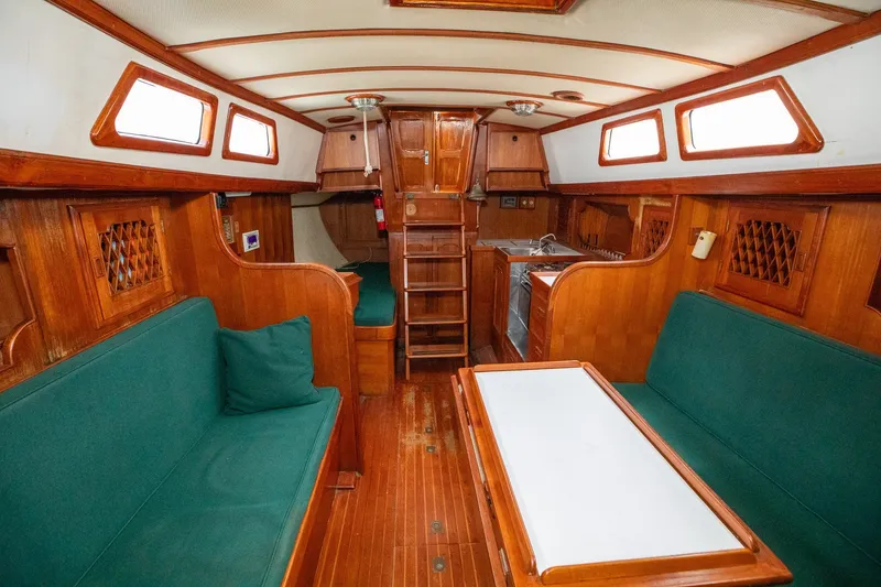 Slide: The Image of Interior of a 1979 C&L Marine 36 sailboat with wooden furnishings and green seating. - 19