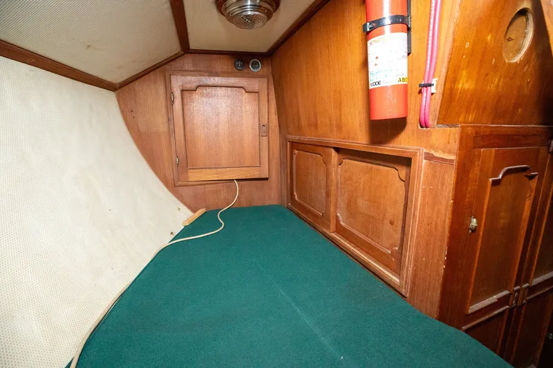 Slide: The Image of 1979 C&L Marine 36 cabin interior with wooden paneling and green bedding. - 32