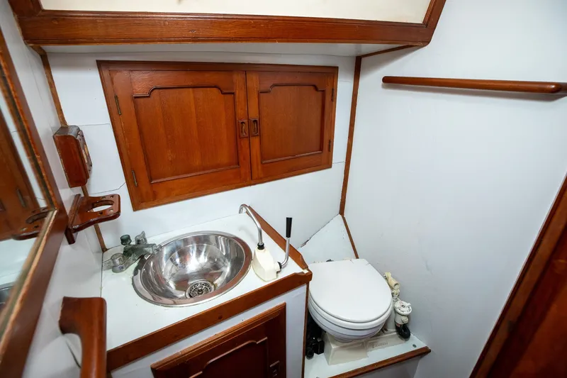Slide: The Image of 1979 C&L Marine 36 yacht bathroom with wooden cabinets and stainless steel sink. - 39