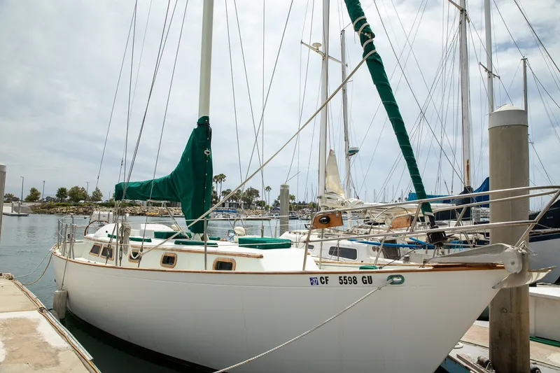 Slide: The Image of 1979 C&L Marine 36 sailboat docked at marina with green sail covers. - 1