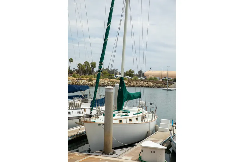 Slide: The Image of 1979 C&L Marine 36 sailboat docked in a marina, surrounded by calm waters. - 4