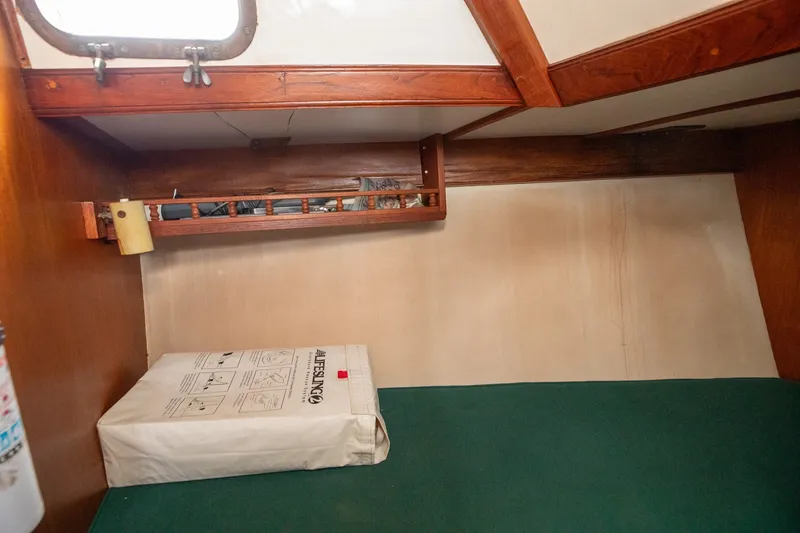Slide: The Image of 1979 C&L Marine 36 cabin interior with wooden accents and green bedding. - 36