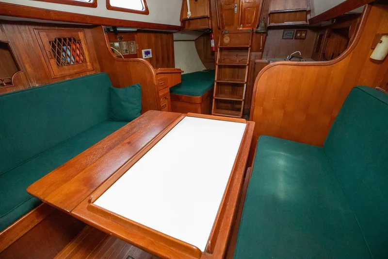 Slide: The Image of Interior of a 1979 C&L Marine 36 sailboat with wooden furnishings and green seating. - 26
