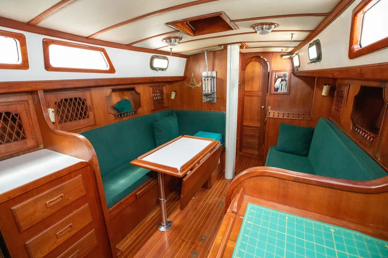 Slide: The Image of Interior of a 1979 C&L Marine 36 sailboat with wooden furnishings and green seating. - 23