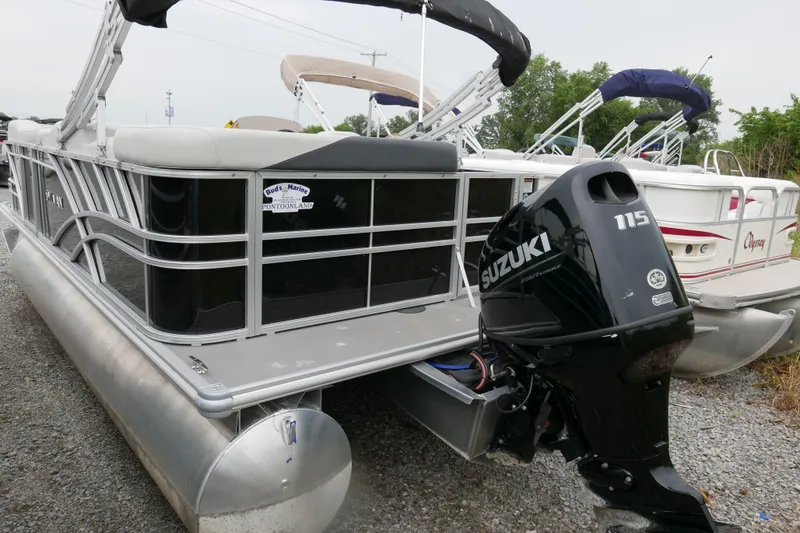 Slide: The Image of 2025 Sylvan Mirage 820 Cruise pontoon boat with Suzuki 115 outboard motor, parked on gravel. - 3