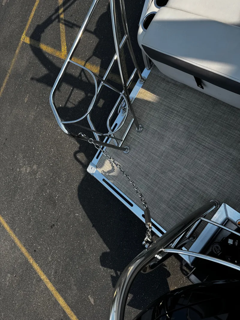 Slide: The Image of Part of a Harris Cruiser 230 pontoon boat with metal railing and gray flooring. - 25
