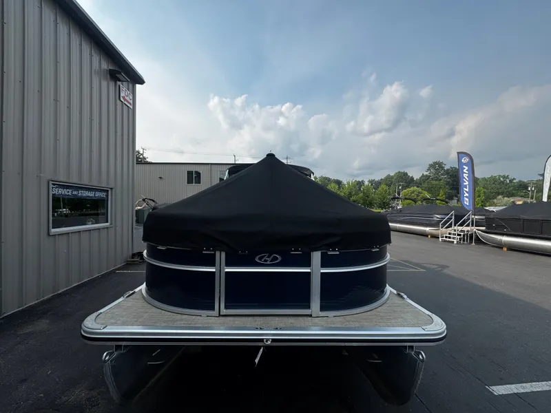 Slide: The Image of A 2021 Harris Cruiser 230 pontoon boat is parked in front of a building. - 27