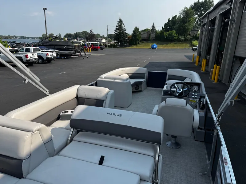 Slide: The Image of The image shows a 2021 Harris Cruiser 230 pontoon boat with gray upholstery and a helm station. - 20