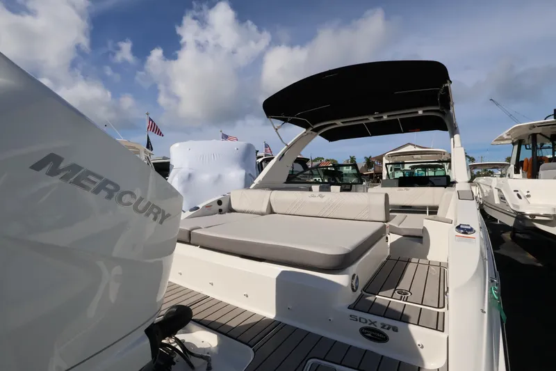 Slide: The Image of The image shows a Sea Ray SDX 270 Outboard boat with a spacious seating area and sunshade. - 7