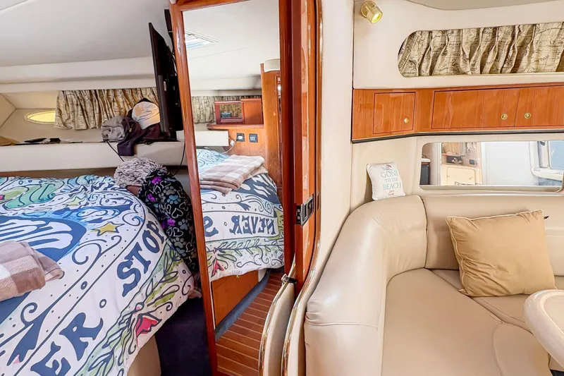 Slide: The Image of Interior of 1997 Sea Ray 370 Express Cruiser with cozy seating and vibrant bedding. - 25