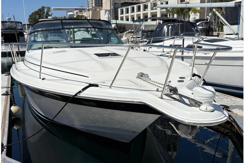 Slide: The Image of 1997 Sea Ray 370 Express Cruiser docked at marina, with cityscape backdrop. - 11