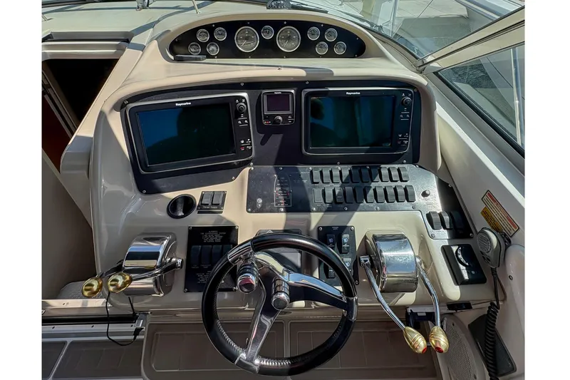 Slide: The Image of 1997 Sea Ray 370 Express Cruiser helm with dual screens and control panel. - 19